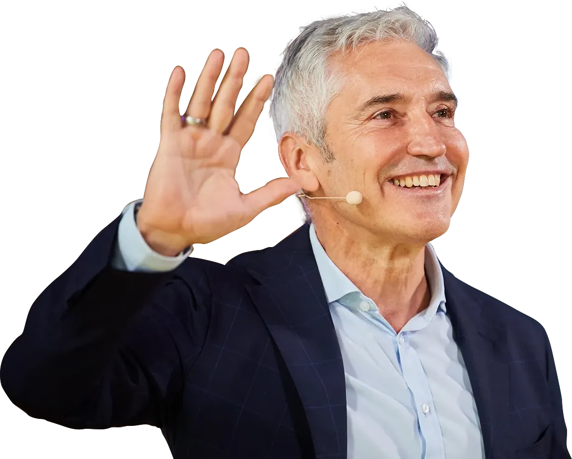 Dr. Gerd Wirtz, Longevity Speaker, lächelt und winkt mit Headset-Mikrofon